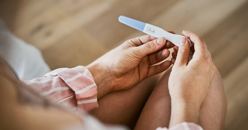 Woman holding pregnancy test infertility