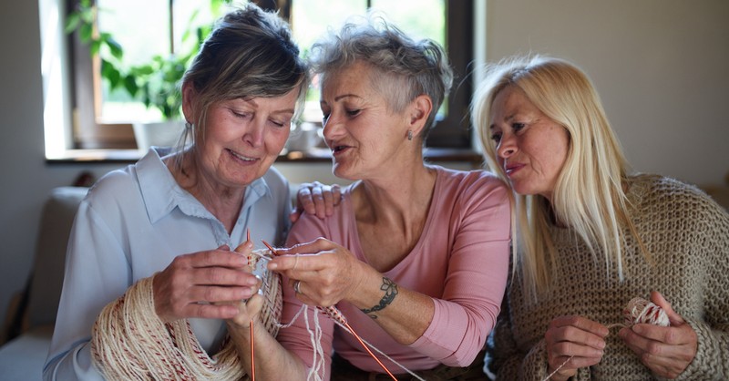 senior women friends learning to knit and craft