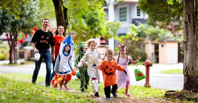 family trick or treating in neighborhood on halloween