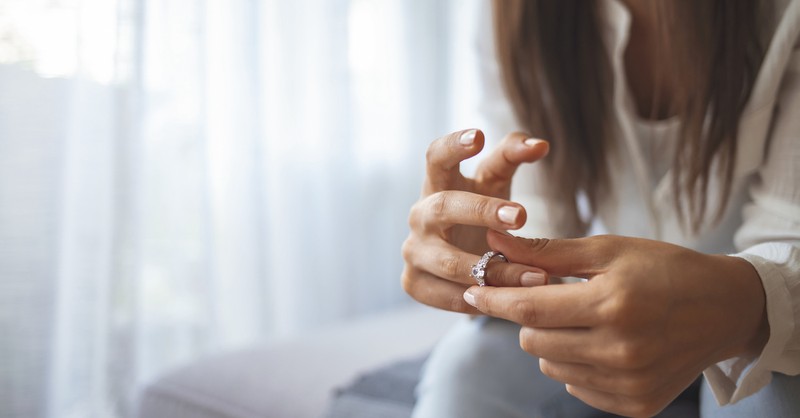 Woman taking off engagement ring thinking break up proposal