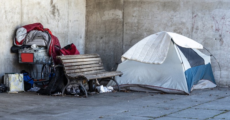 Tent and belongings set up on a street corner for a homeless person