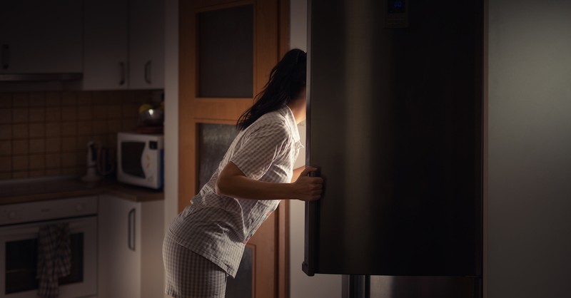 woman looking in fridge for a snack