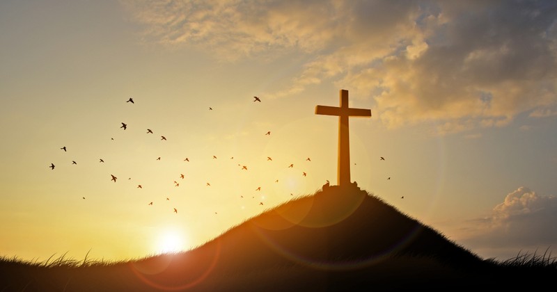 Cross on a Hill with a Sunrise in Background