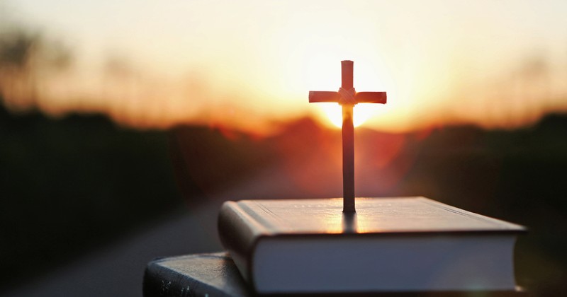 cross and bible with a sunrise
