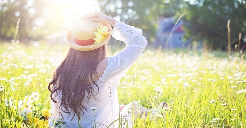 Woman sitting in a blooming field in the Spring.