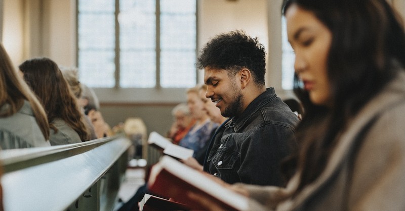 people sitting in church pews singing