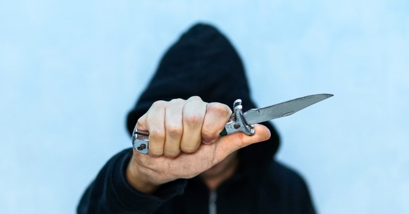 man with hoodie carrying switchblade knife to illustrate nicky cruz, people god used to do extraordinary things