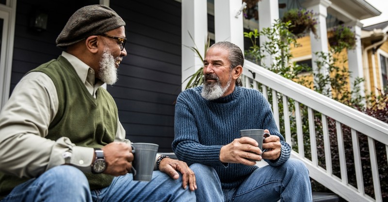 Two senior men having a conversation on the porch