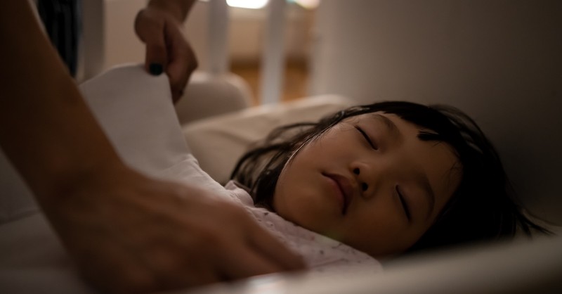 Little girl asleep in bed dreaming