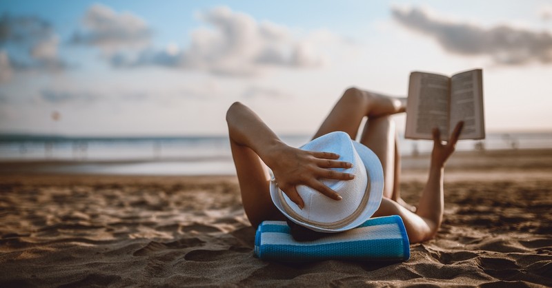 Reading book in summer on beach relaxing peaceful