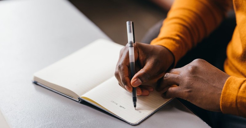 A person writing in a notebook