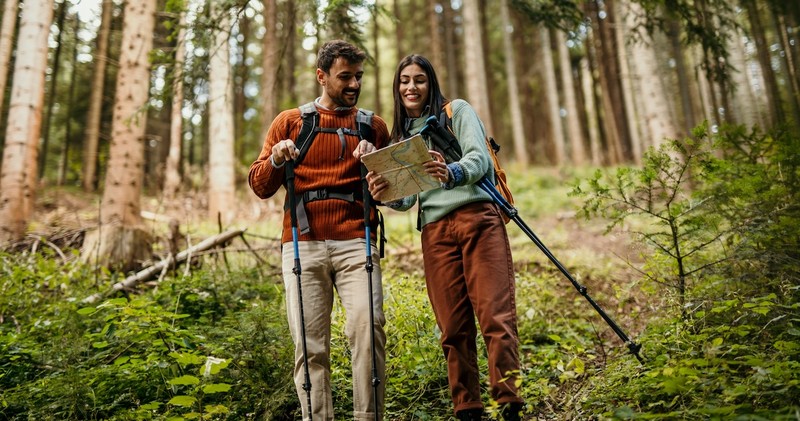 Happy married couple outside hiking backpacking exploring hiking trail