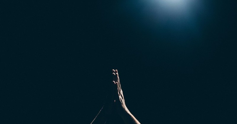 dark background with hands praying; praying at night
