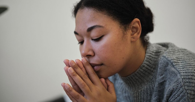 Woman praying; Woman praying with hand over her mouth