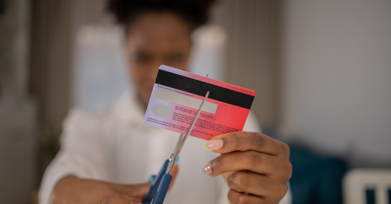 person cutting credit card debt free