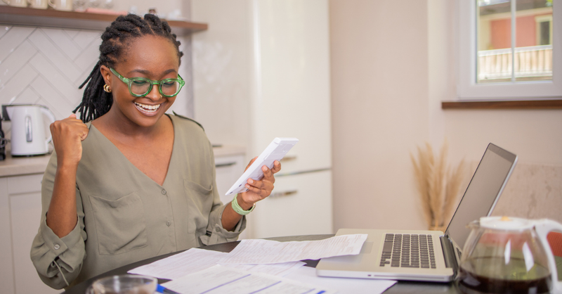relaxed woman paying bills laptop coffee at home stress free