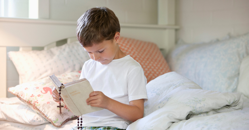 A boy holding a Bible before school.