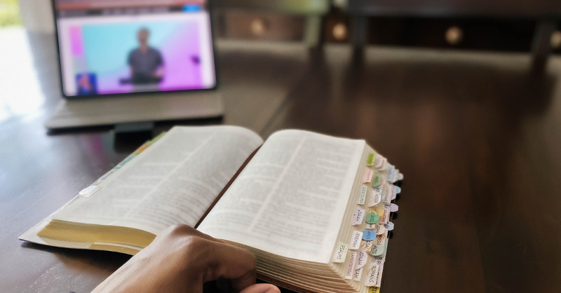 Someone turning off their phone next to an open Bible