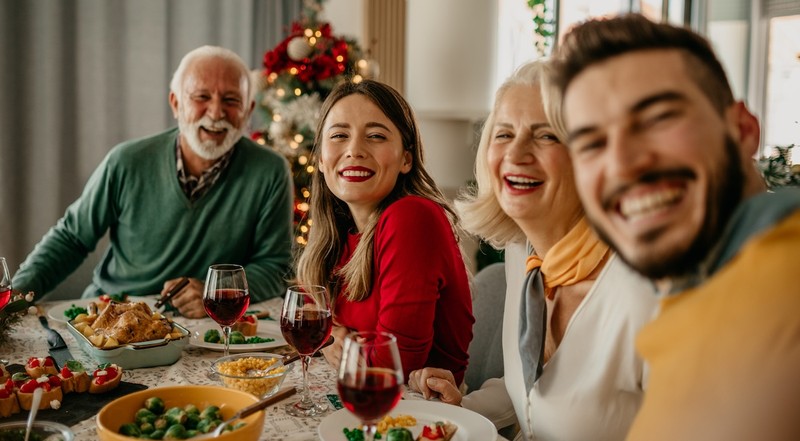 Married couple adult children with in-laws parents family for Thanksgiving Christmas holiday dinner at table