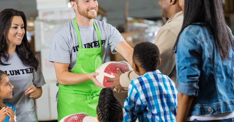 Volunteers passing out turkeys at holiday food donation drive