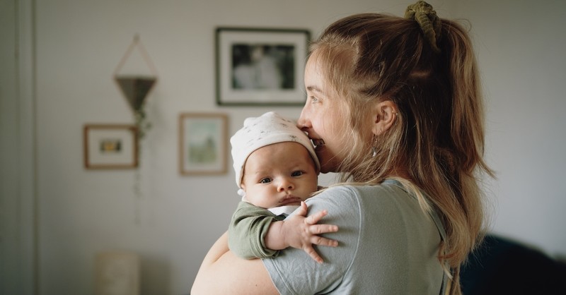 Mom holding newborn baby in nursery