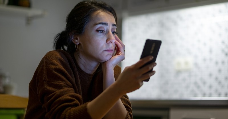 Woman on phone social media posting cellphone stressed overwhelmed
