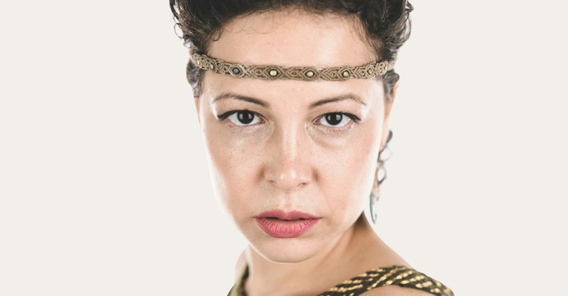 A close-up portrait of a woman wearing a simple headband reminiscent of Biblical times, looking ahead with a calm and determined expression, symbolizing courage, leadership, and faith.