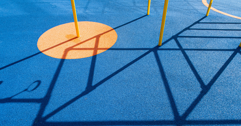 An empty playground casts long shadows across bright blue pavement, symbolizing childhood experiences, emotional wounds, and God's healing work in restoring the heart and renewing faith.