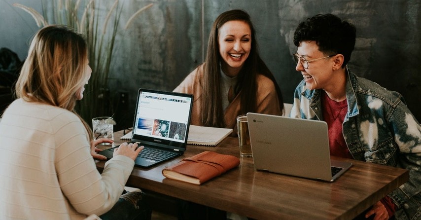 Three people at table laughing, prayers for end of semester