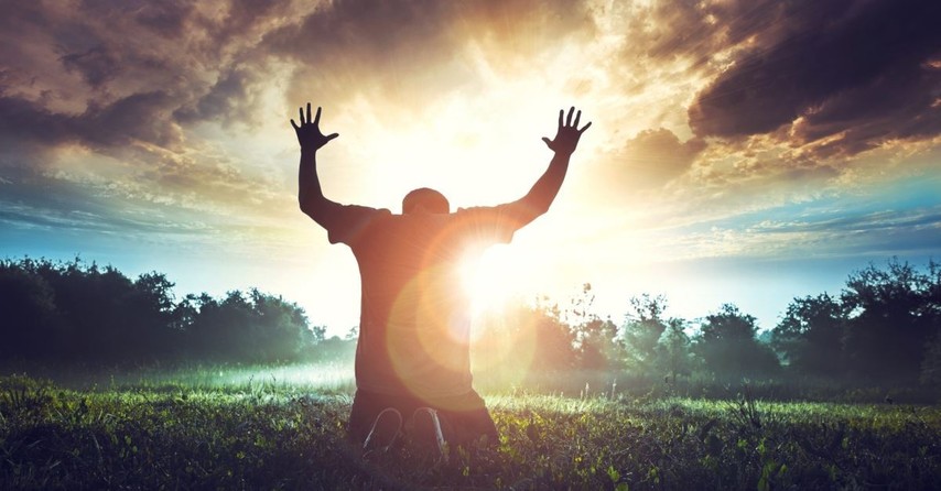 man kneeling at sunrise