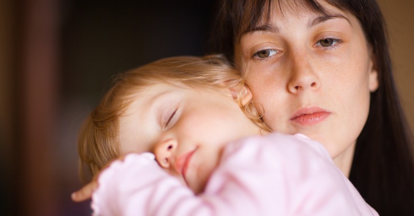 mom carrying sleeping baby