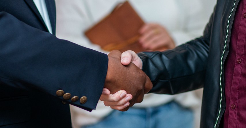 closeup of two men shaking hands greeting at church