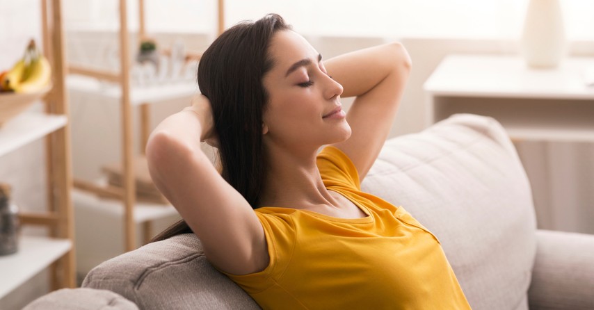 woman hands behind head relaxing at home positive affirmations