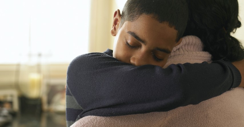 close up of young boy giving mom a hug