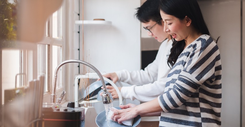 couple cleaning together in kitchen