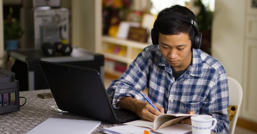 Teen boy doing schoolwork on a laptop