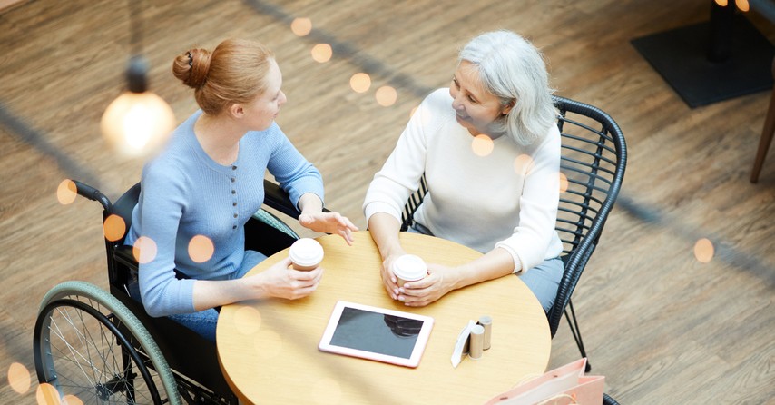 friends one in wheelchair having coffee and conversation