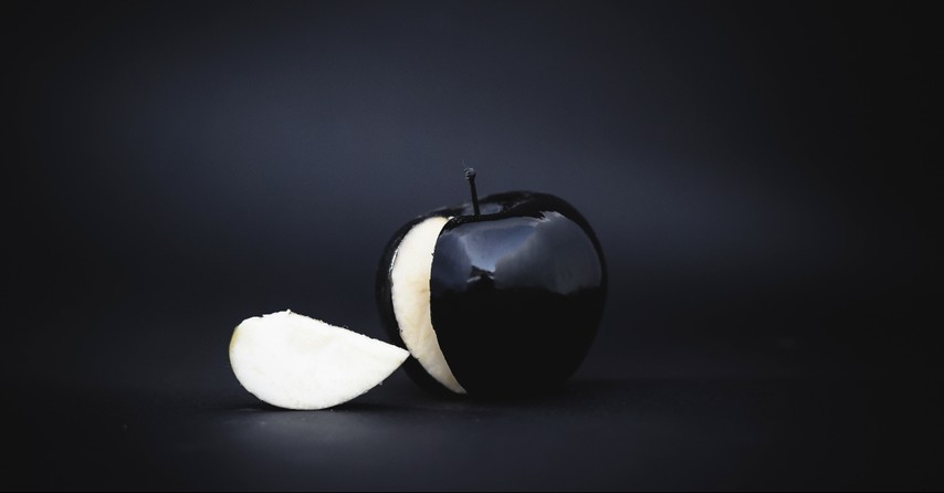 A black apple with a black background