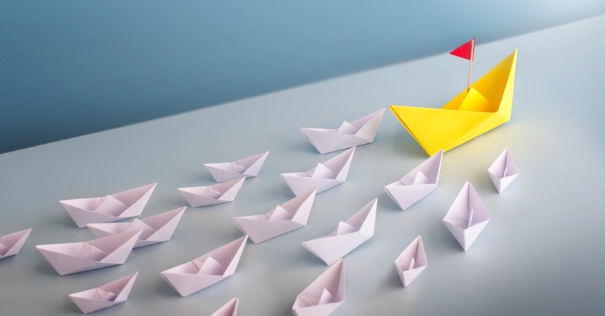 Small paper boats following one leader