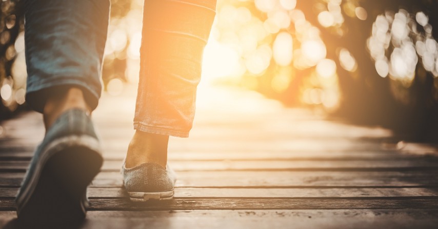 Feet walking across a wooden bridge