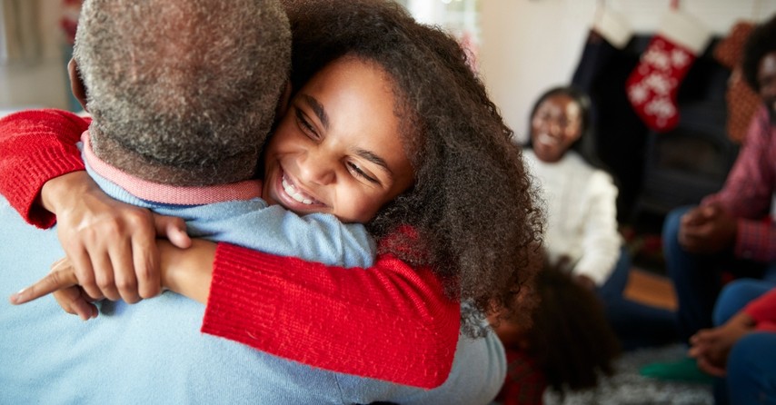 granddaughter hugging her grandfather at christmas, old fashioned traditions