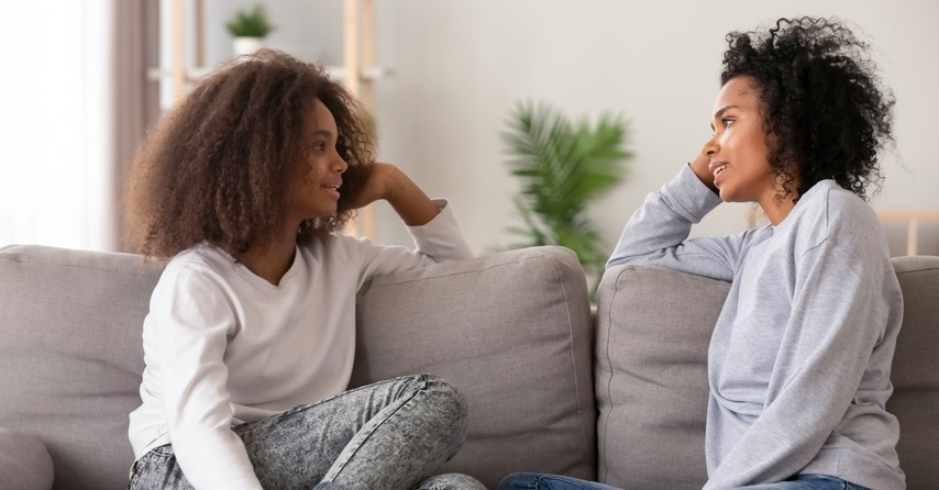 mom and daughter having a talk on the couch, how to make the talk with your teen less cringy