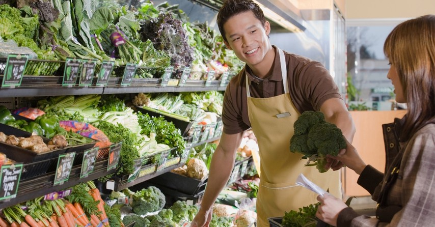 Grocery store worker helping a woman