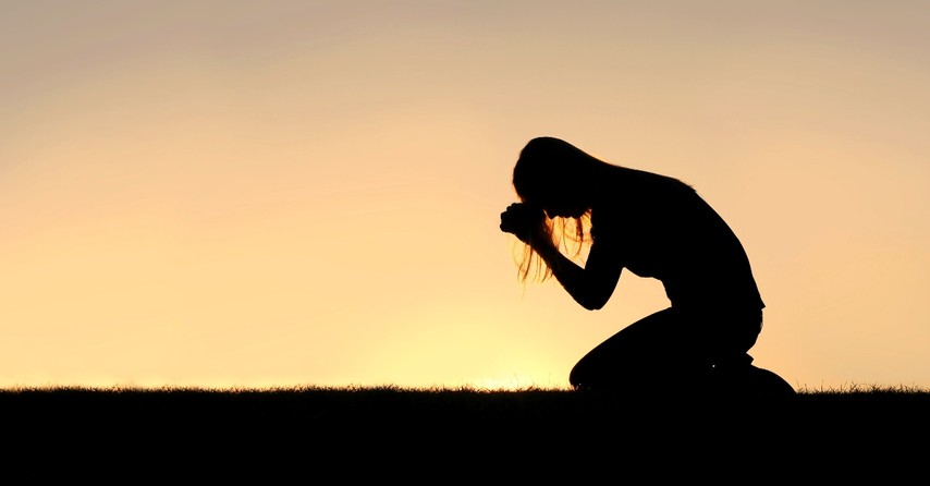 silhouette of woman praying kneeling