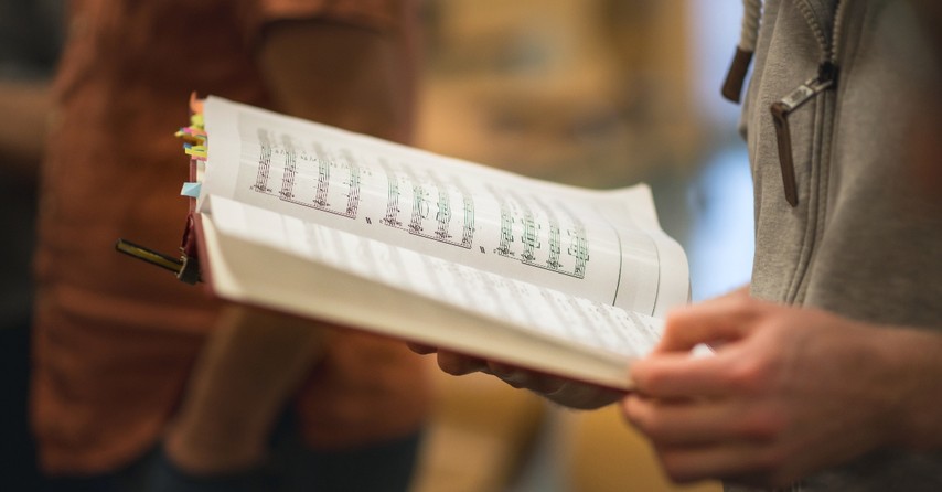 Man holding a hymnbook and singing