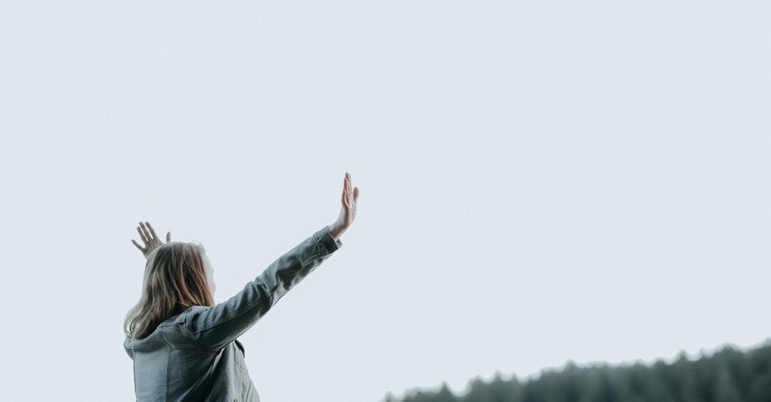 Woman raising hands outside