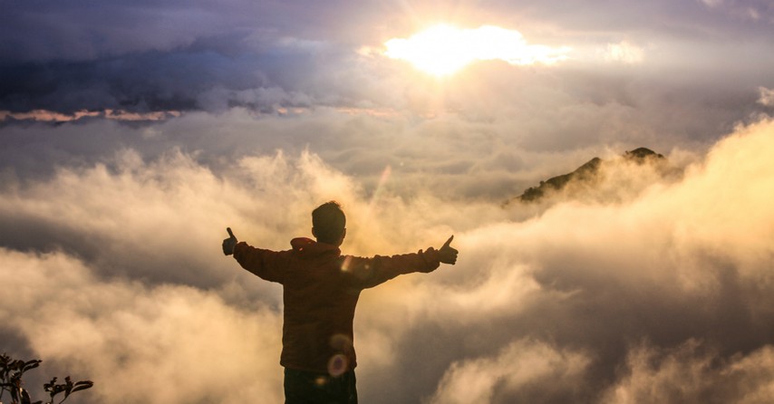 Man giving thumbs up to the sunrise