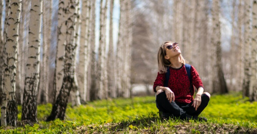 Woman looking up in the woods