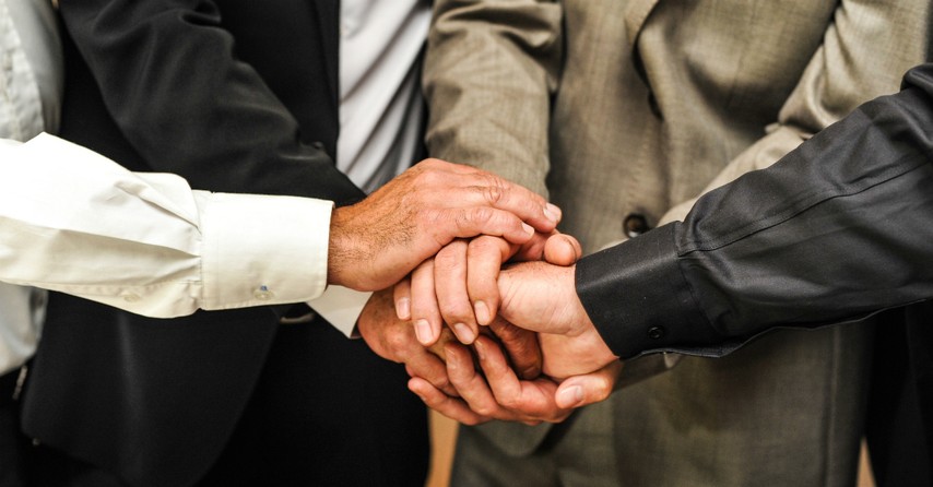 Group of men with their hands together