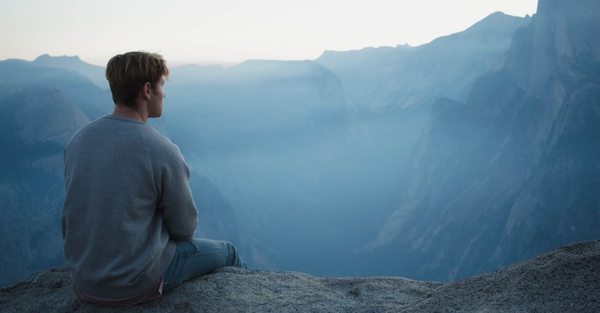 Man on a cliff thinking